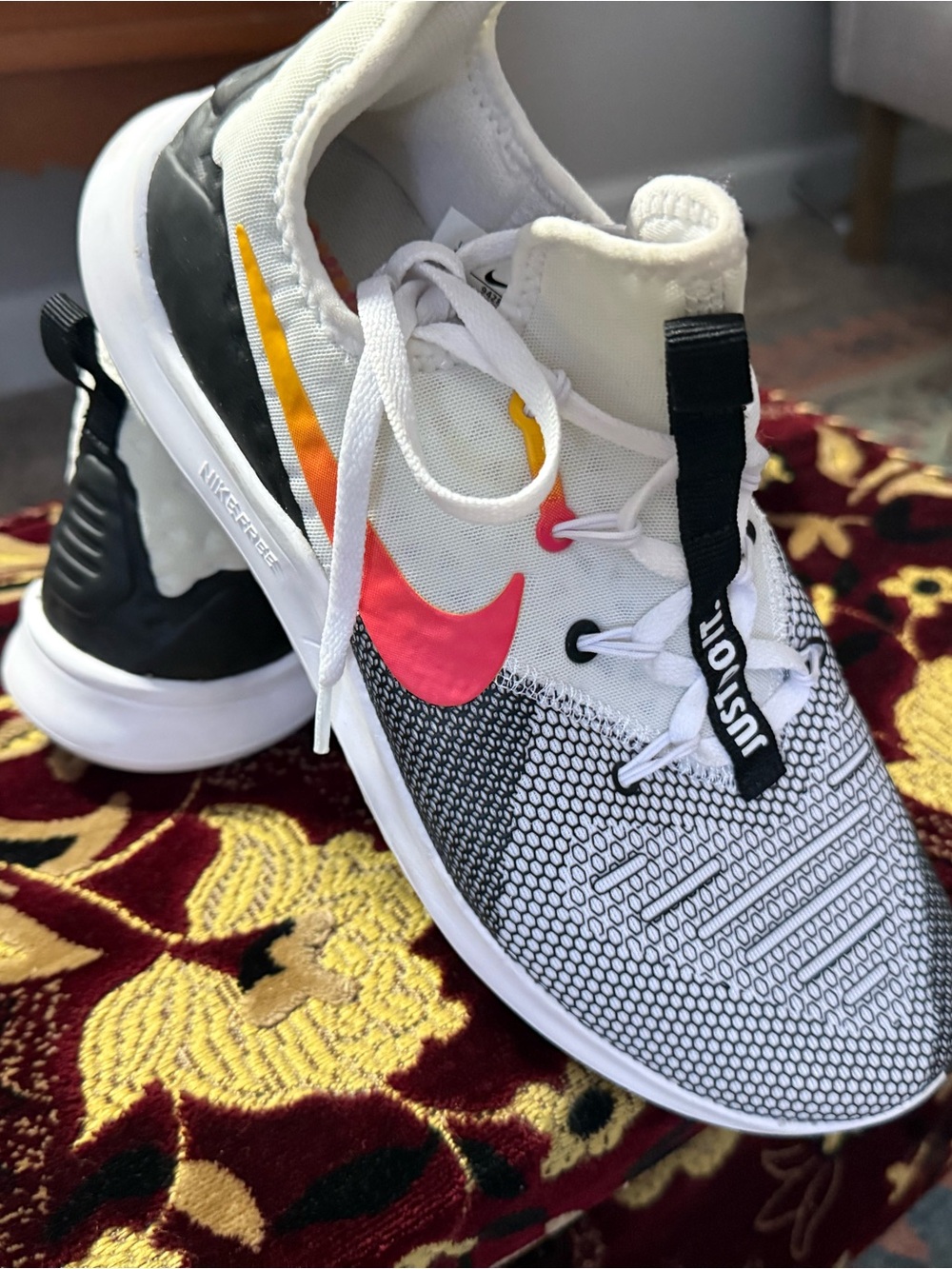 Nike White Flyknit Sneakers with Pink & Yellow Swoosh Accents